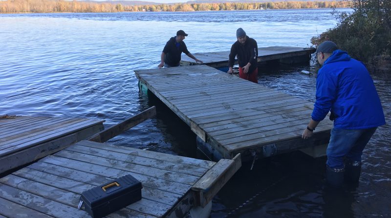 Modern Niagara employees brave the frigid Ottawa River to help bring in docks for the winter. Photo submitted