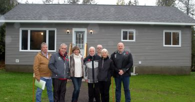 From left, Kerry Bourgaize, Coun. Eli El-Chantiry, Kelley Foley, Don Goodwin, Guildcrest Homes' George Tireney, Linda Couturier and Guildcrest Homes' Sean Kelly pose in front of rural Ottawa's first coach house. Photo by Jake Davies