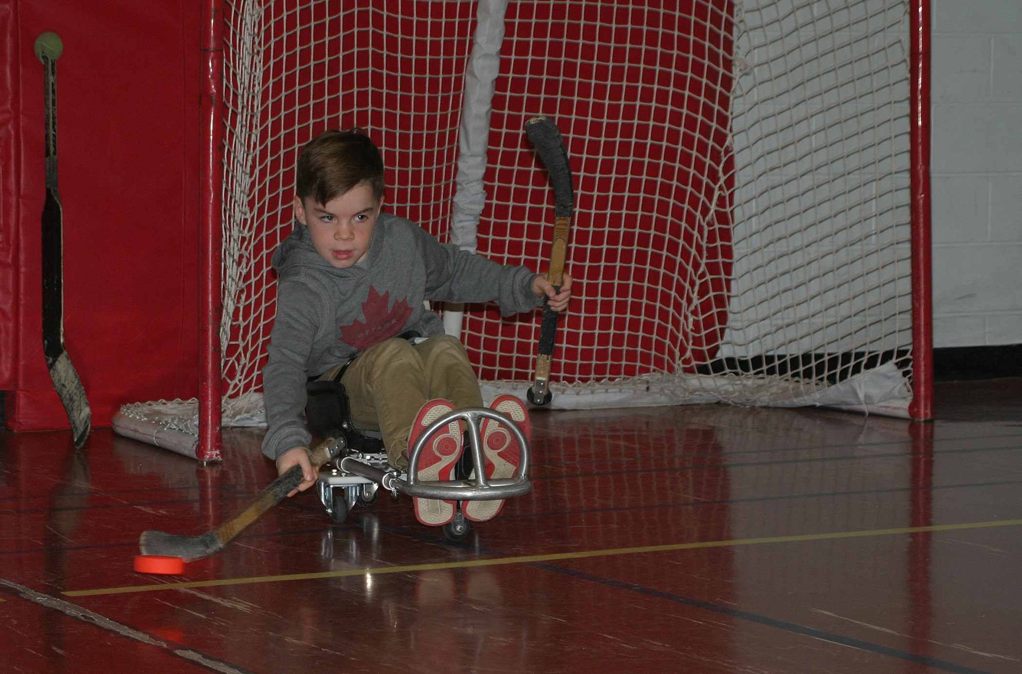 Griffin Weir gives dryland sledge hockey a try in a sepcially modified sled provided by The Abilities Centre. Photo by Jake Davies