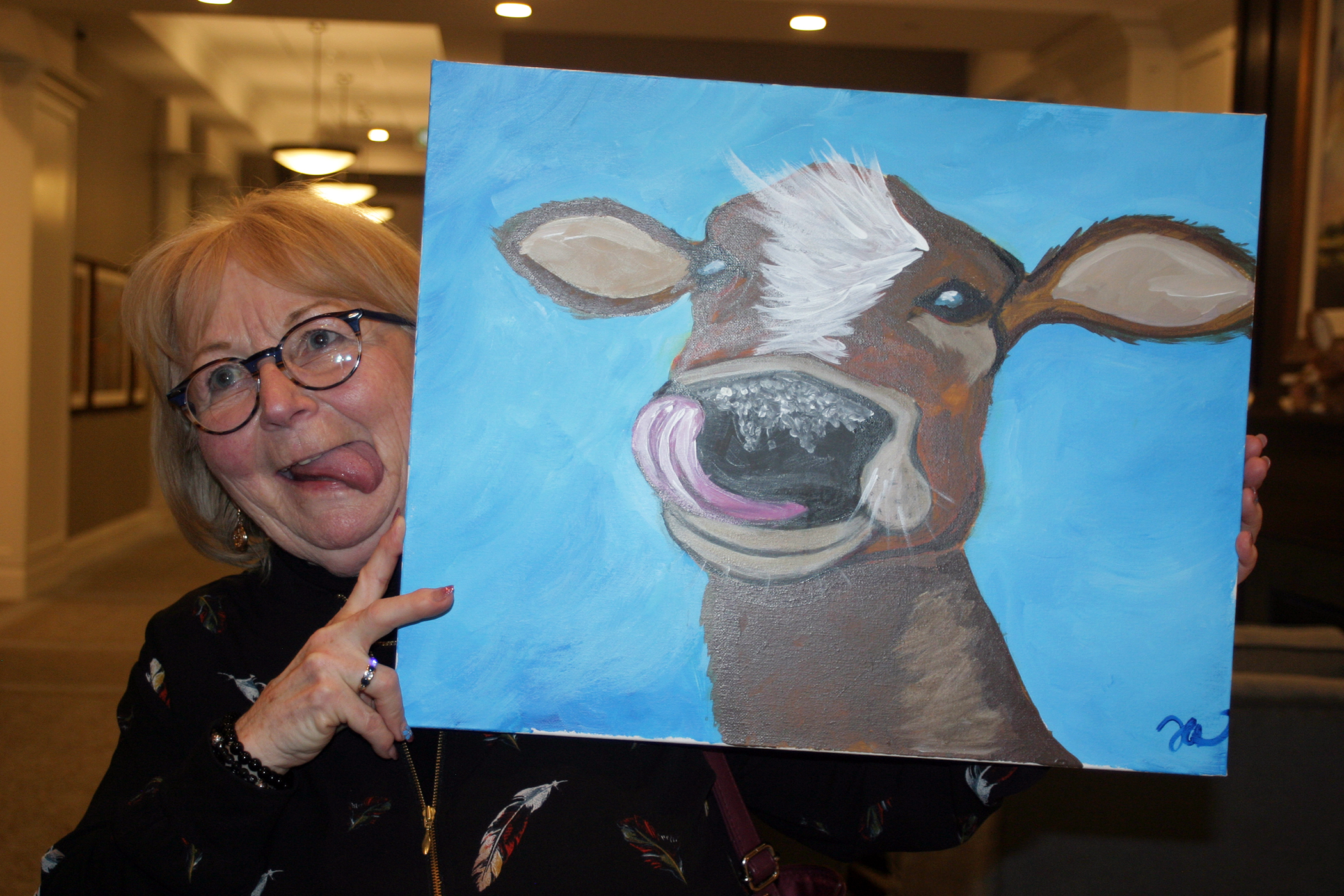 Pam Meunier, doing her best cow painting impression, was the highest bidder on CHA board member Tara Azulay's Paint Night creation. Photo by Jake Davies
