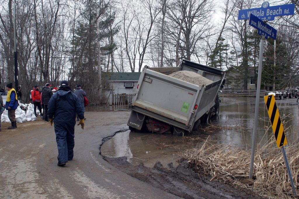 This dump truck was inches away from tipping after trying to sneak by the sandbagging station. Getting it unstuck caused significant delays in flood relief preparations. Photo by Jake Davies﻿