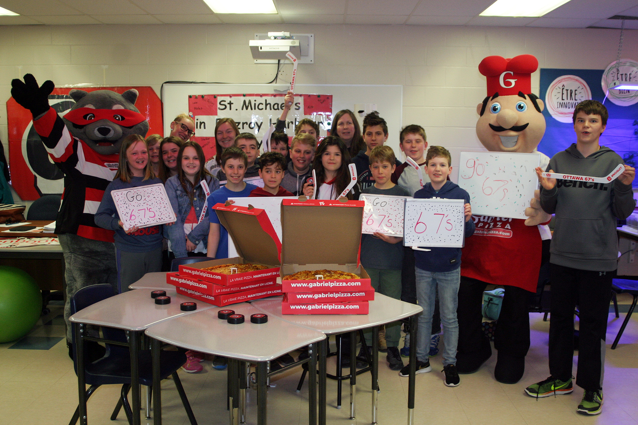 The class, the mascots and the pizza pose for a photo. Photo by Jake Davies