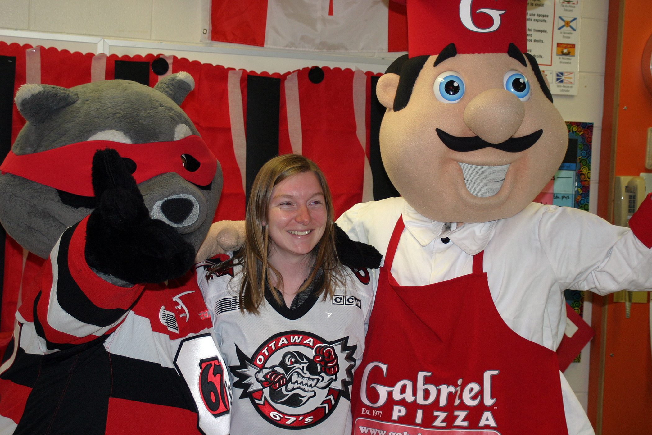 Teacher Kathryn Erickson, a lifelong 67's fan, is sandwiched by Riley and Gabriel. Photo by Jake Davies