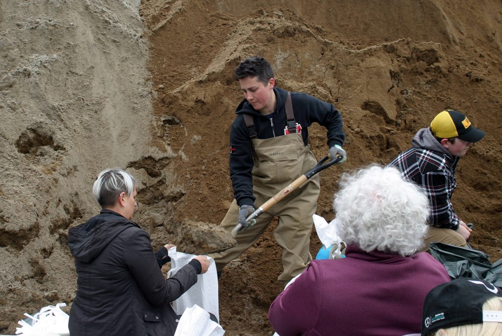 Volunteer firefighter Ash Weaver, whose basement was flooded and heavily damaged in 2017, was filling sandbags at St. Gabriel's Church yesterday. Photo by Jake Davies﻿