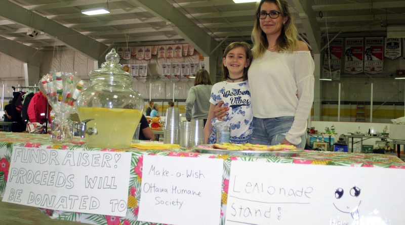 A mother and daughter pose at their stand.