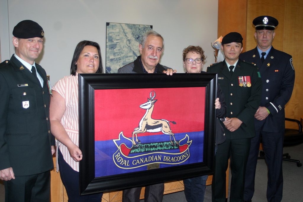 The same crew poses with the Royal Dragoon regimental flag. Photo by Jake Davies