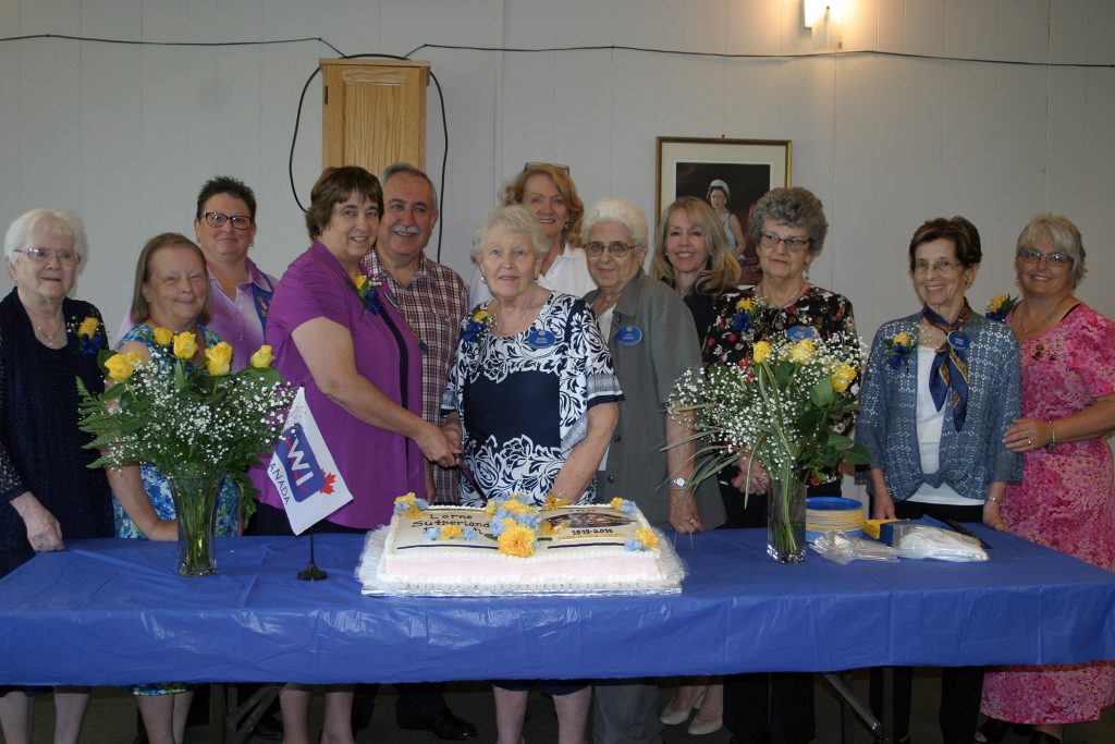 Members and dignitaries pose with cake at the 100th anniversary of the Lorne Sutherland WI. Photo by Jake Davies