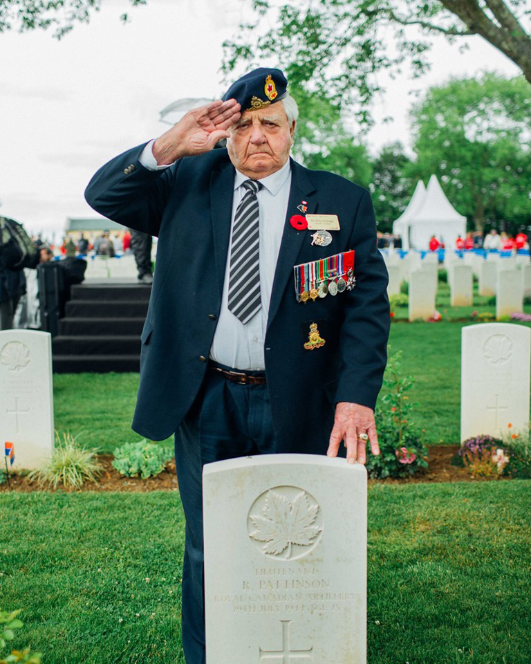 Dr. Roly Armitage poses in front of the gravestone of his officer Roy Pattinson who died in combat. Courtesy Dr. Roly Armitage