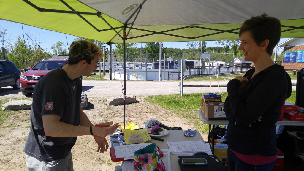 WCSS student Alex Desjardin tells his story of needed volunteer hours to WCDR co-chair Alex Lesnick while registering to help with clean-up. Photo by Jake Davies