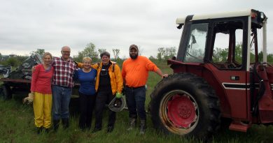 From left, Christiane Stieber, Michael Stieber, Jill Seymour, Ruth Sirman and Tim Hayes pose for a photo during a break in tornado clean-up work last Sunday. Notice Michael's tractor no longer has windows due to tornado damage. Photo by Jake Davies