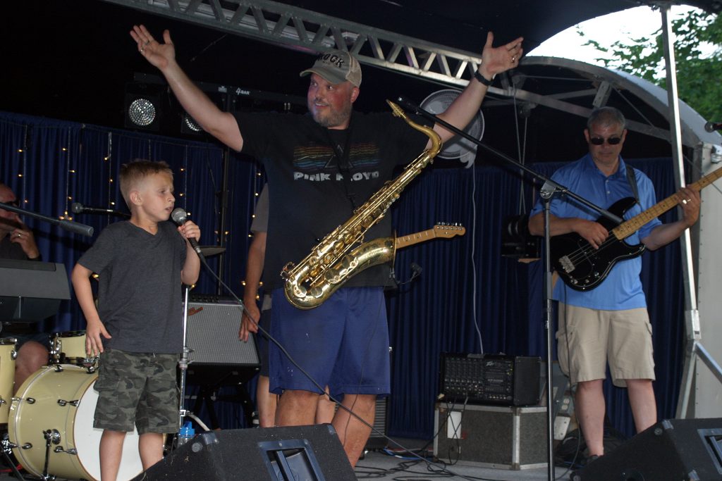 J.J. Craig, 6, performs I'm Still Standing at last week's Concerts in the Park while Dave Rama pumps up the crowd. Photo by Jake Davies