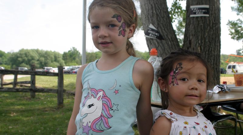 From left, Harbour girls June, 6, and Samantha, 2, show off their amazing art work after gettting painted at the Kids Fair Saturday afternoon. Photo by Jake Davies