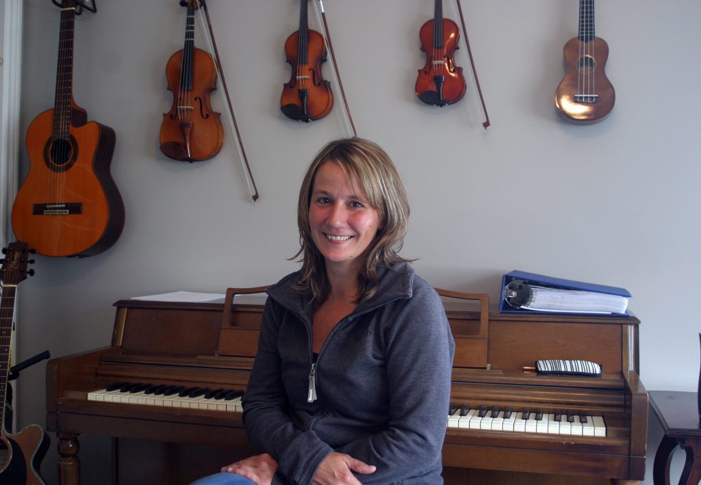 Musician Jennifer Johnson poses at her piano in her new studio at the Village Station in Carp. Photo by Jake Davies