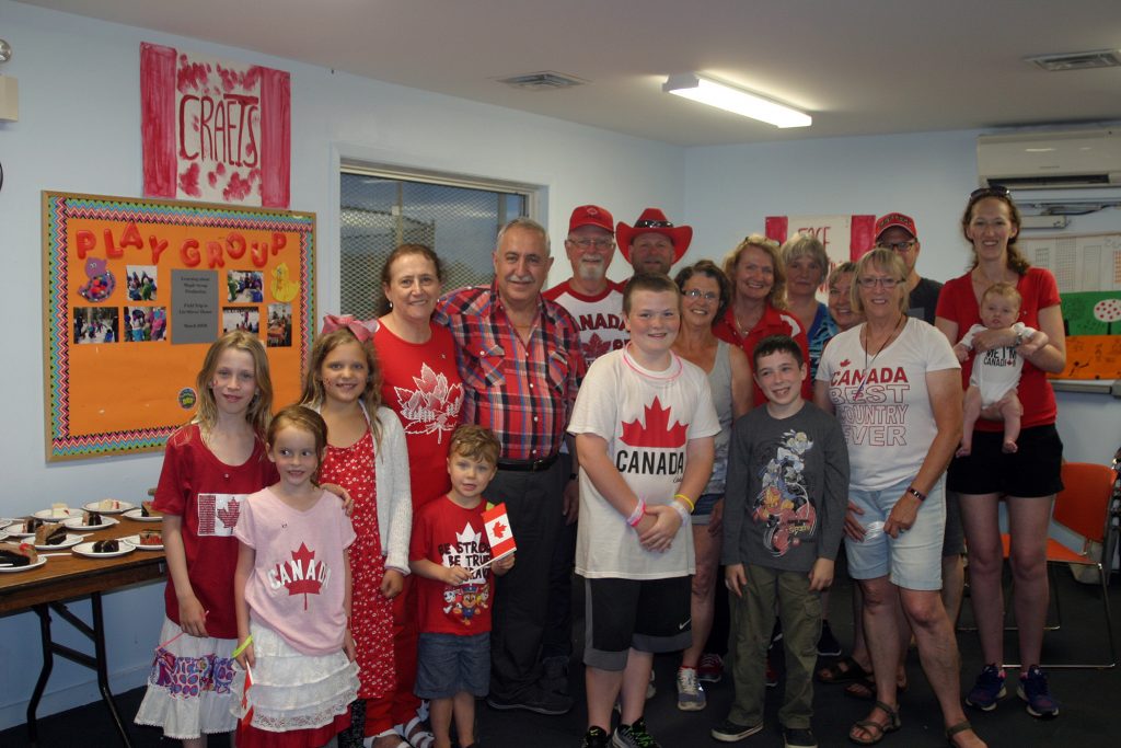 Volunteers and guests pose for a photo at the Corkery Canada Day party before getting their hands on all that cake. Photo by Jake Davies﻿