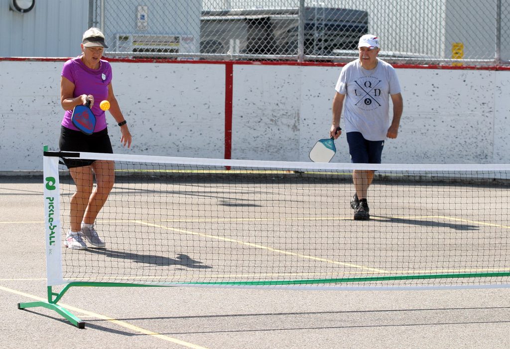 Connie Atherfold 'dinks' the ball whil her partner Coun. Eli El-Chantiry looks on in Saturday morning pickleball action. Photo by Jake Davies