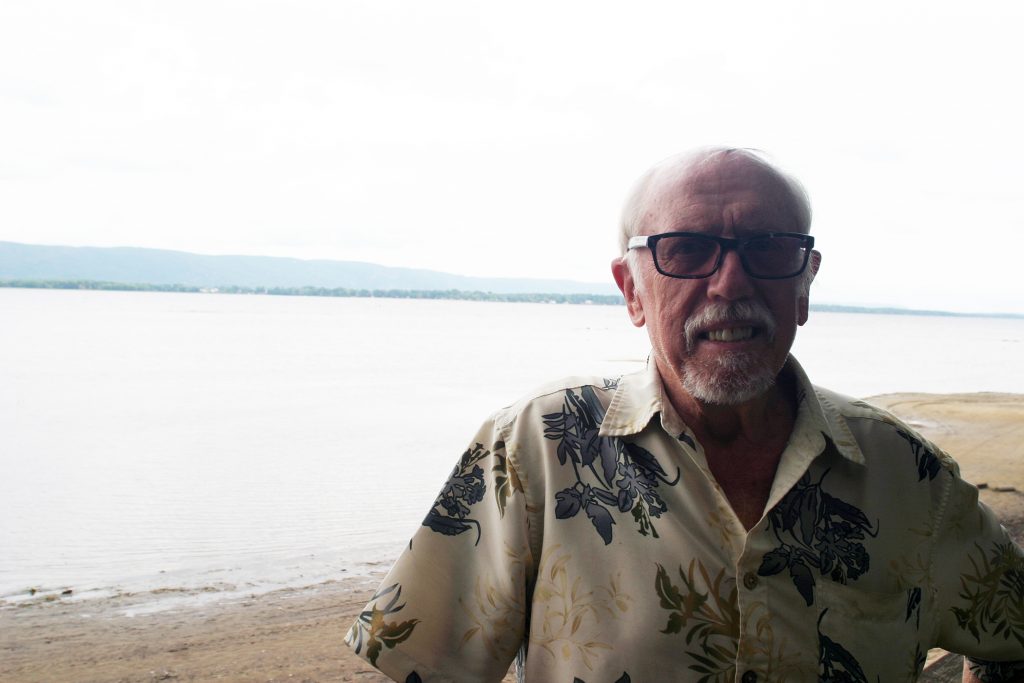 Constance Bay resident Gerry Blyth, photographed in his back yard with the Ottawa River at his back, says the extreme flooding official story doesn't add up. Photo by Jake Davies