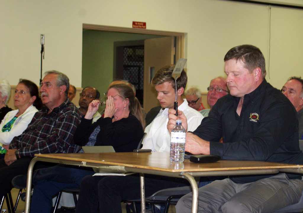 ARFA member Bruce Hudson holds the spatula of power, timing candidates' responses during the debate. Photo by Jake Davies