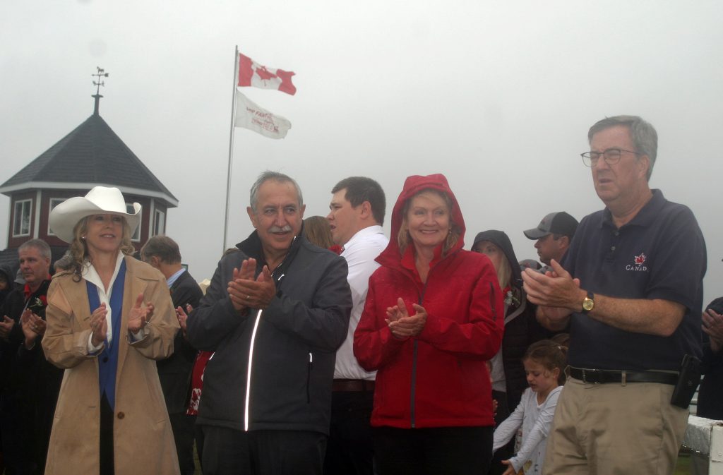 ﻿From left, MPP Dr. Merrilee Fullerton, Coun. Eli El-Chantiry, MP Karen McCrimmon and Mayor Jim Watson applaud during speeches at the 156th Carp Fair Ceremonial Parade with the Carp Fair flag blowing in the breeze in the background. Photo by Jake Davies