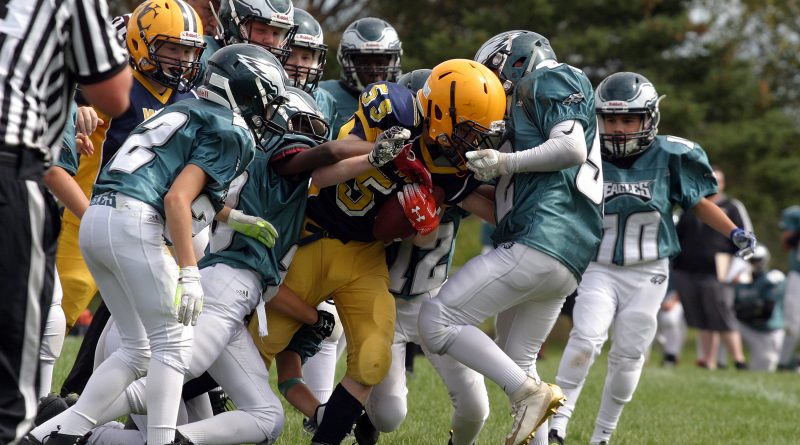 It took the entire Eagles team to tackled Wolverine RB Owen Redmond during last Sunday's pee wee game. And they still got a face-masking penalty on the play. Photo by Jake Davies