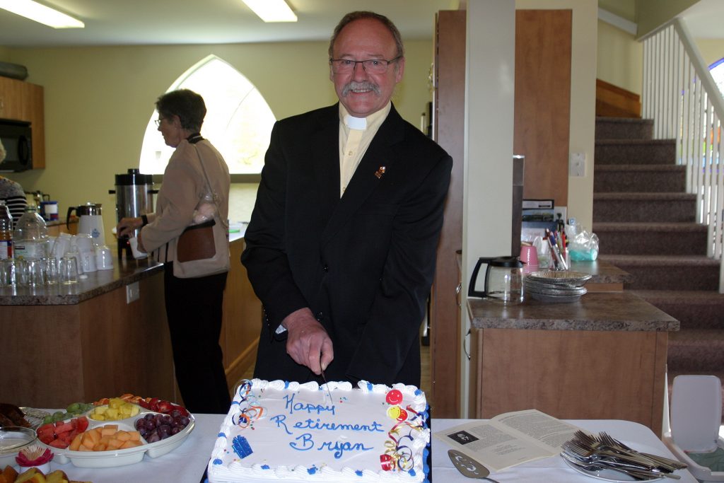 Rev. Bryan Ransom poses with the retirement cake the Bethel-St. Andrew's United Church made him. Photo by Jake Davies