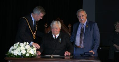 Dr. Roly Armitage signs the induction paper as he is officially sworn in to the Order of Ottawa by Mayor Jim Watson and Coun. Eli El-Chantiry. Photo by Jake Davies