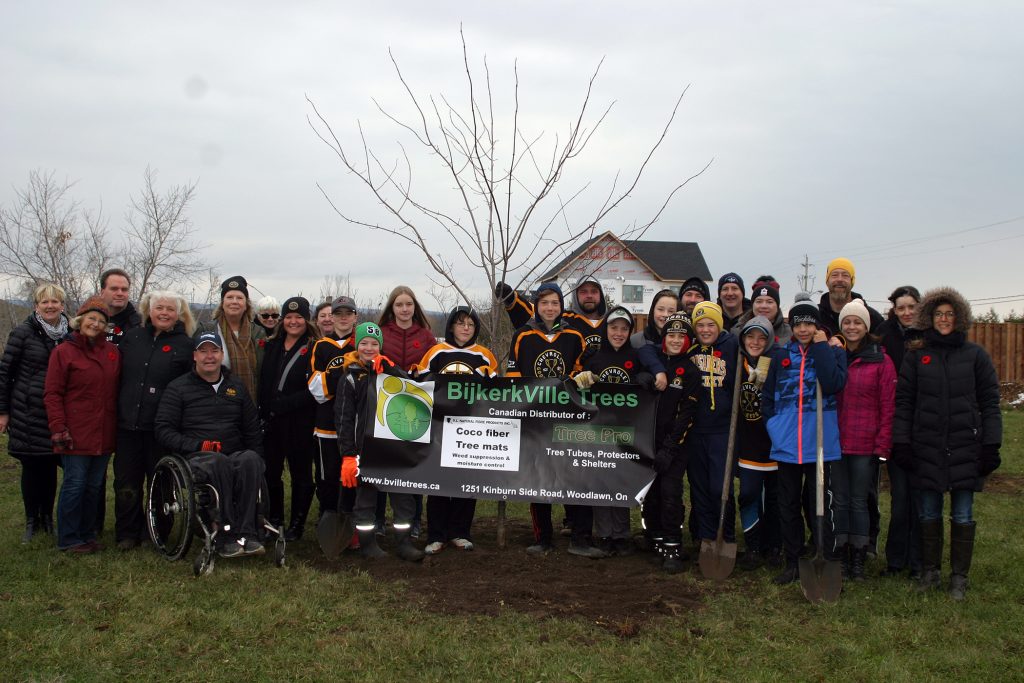 The Warriors, parents, coaches, members of the Women's Institute, the DCA, sponsors and community members pose beside the freshly planted Canadian Red Maple last fall provided by BijkerkVille Trees. Photo by Jake Davies