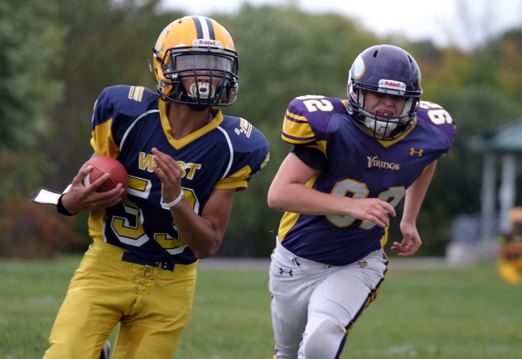 Wolverine quarterback Keegan Brunet runs away from a Gatineau Viking during an early season win. Photo by Jake Davies