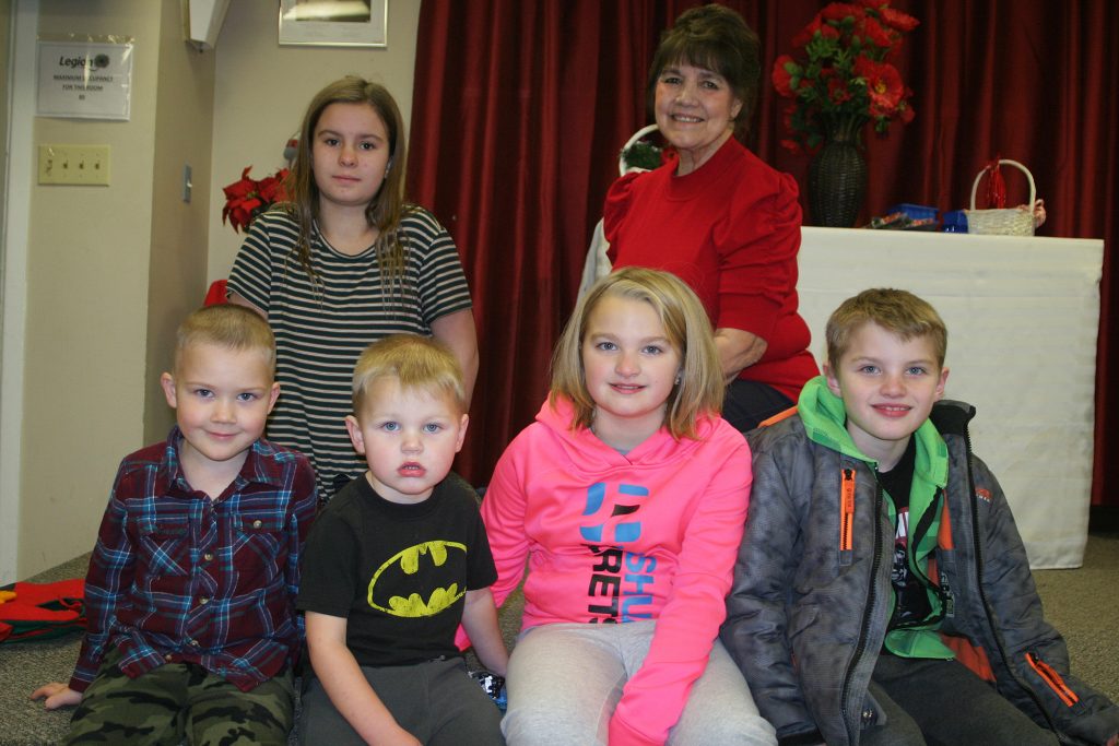 On Sunday the Legion hosted its annual Kids' Christmas Party. In back are volunteers Destiny Rose and Arleen Morrow. In front, from left, are Jamie, 2, Jesse, 5, George, 3, Shannon, 8, and Neil, 8. Photo by Jake Davies