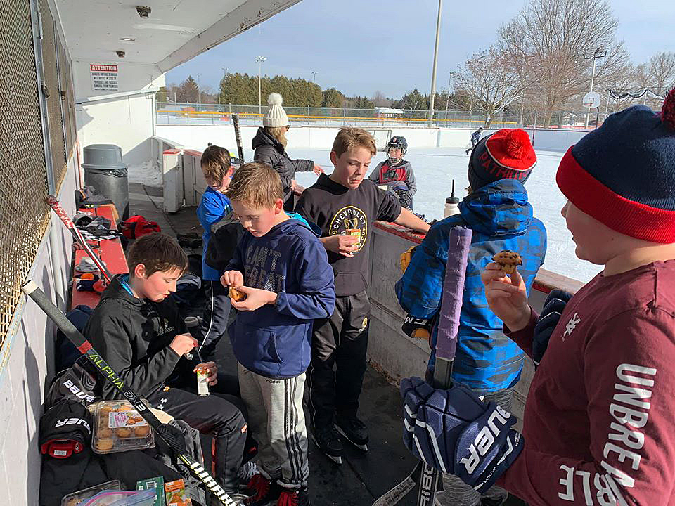 The peewee Warriors get a snack in before heading back out on the ice at the Carp outdoor rink. Photo by Shelley Welsh