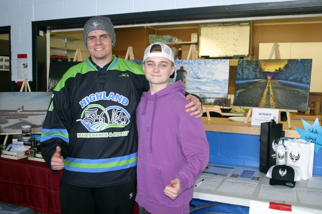 Alex and Kaelen Carlson pose on front of some of Kaelen's photography. Photo by Jake Davies