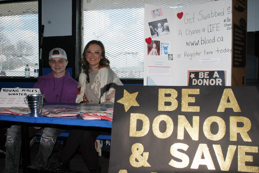 Kaelen Carlson and Kayla Wingrove pose for a photo in front of their booth promoting stem cell donation. Photo by Jake Davies