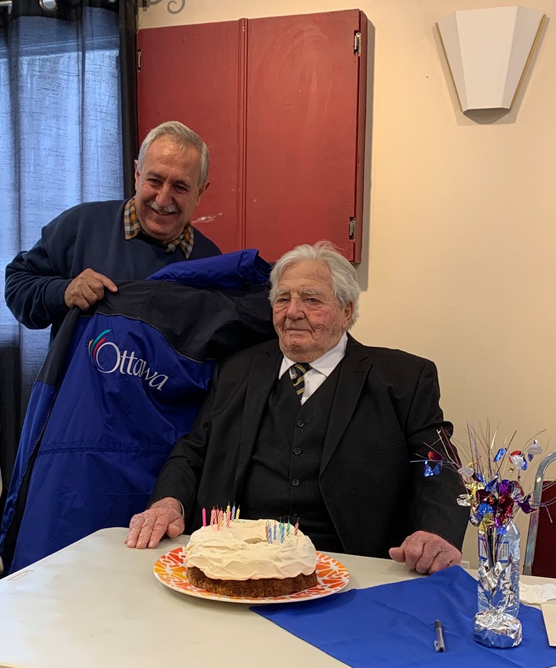 Coun. Eli El-Chantiry gives Roly the jacket right off his back at the WWII veteran's birthday party Sunday. Photo by Lynda Boland