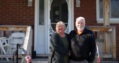 Barb and Leo Enright outside their home on Day Nine of their self-isolation, photographed from a safe distance. Photo by Jake Davies