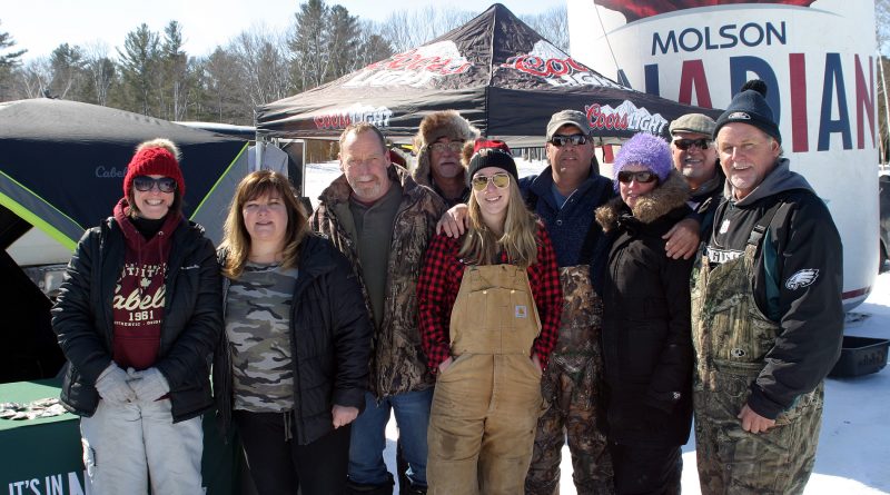 Mike Fine, far right, Peter Strong, third from left, and a gaggle of volunteers pose for a photo at Mike and Peter's 13th Annual Fishing Derby yesterday. Photo by Jake Davies