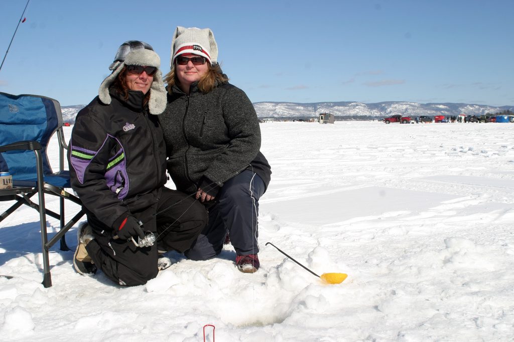 From left, Fitzroy Harbour's Jody Brenton and Arnprior's Catherine Buffam-Jensen pose by their fishing holes. Photo by Jake Davies