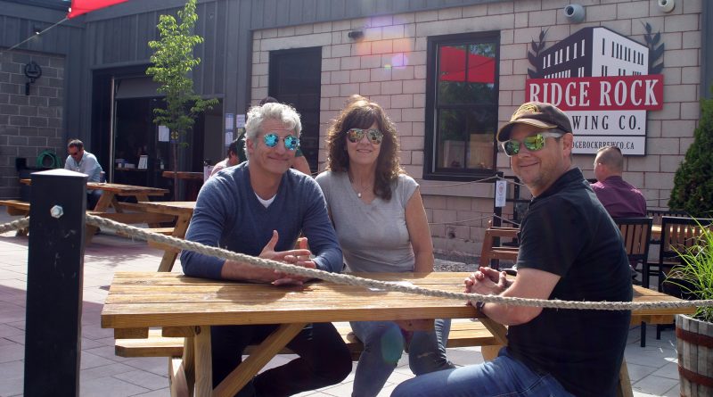 From left, Carl and Lesley Bertrand and Simon Vickery enjoy a cold pint on the Ridge Rock patio Friday afternoon. Photo by Jake Davies