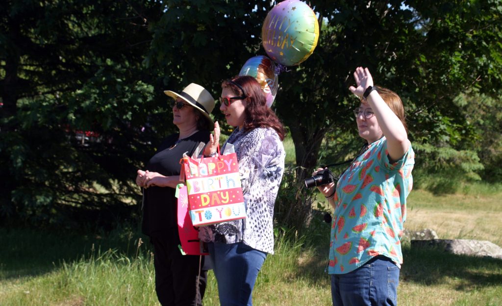 From left, Tracy, Laura and Ross wave to the 35-car parade wishing Laura a Sweet 16. Photo by Jake Davies