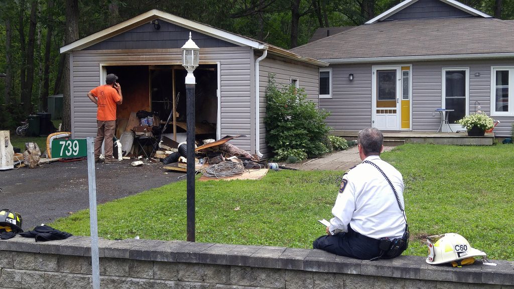 OFS District 6 Chief Bill Bell takes notes for his after-incident report following a garage fire this afternoon (Aug. 21). Photo by Jake Davies