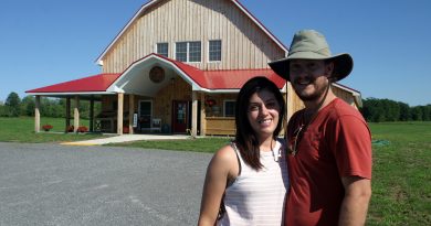 Greg Bell and Brianna Di Labio pose outside their new barn, the centrepiece of March Meadow Farm just outside of Dunrobin. Photo by Jake Davies
