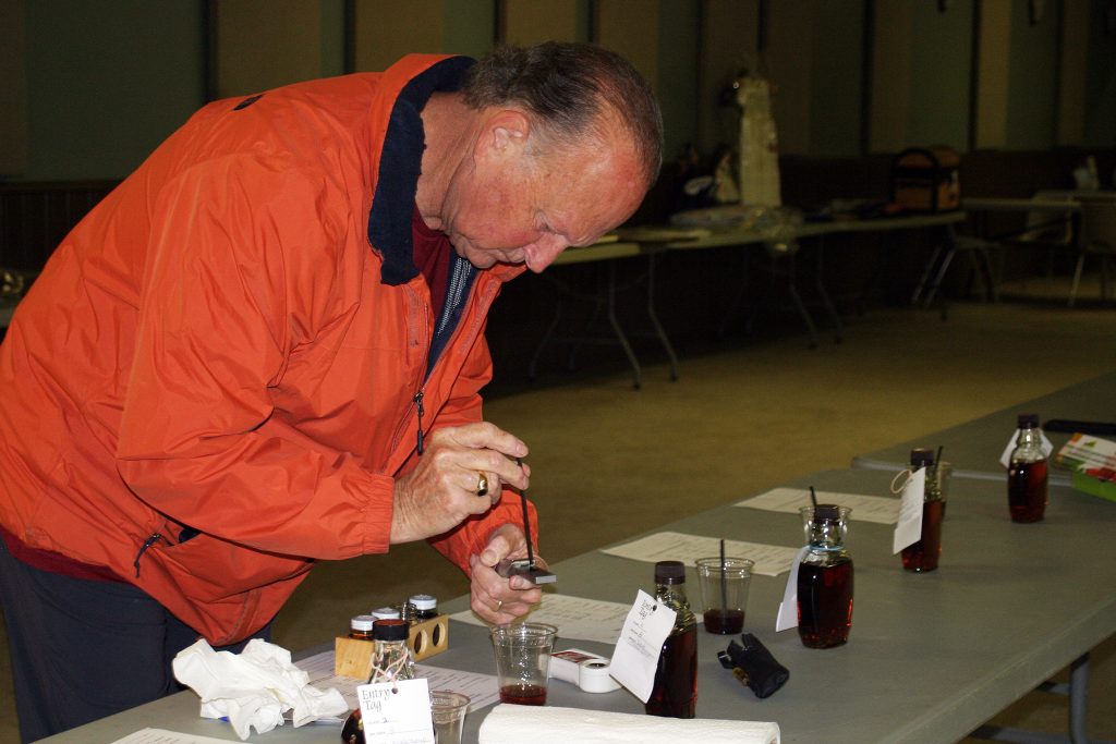 Michael Walters checks the suguar content of syrup submitted in the Carp Fair 2020 Showcase.