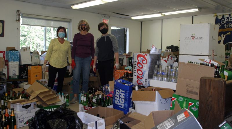 Volunteers pose with empty bottles.