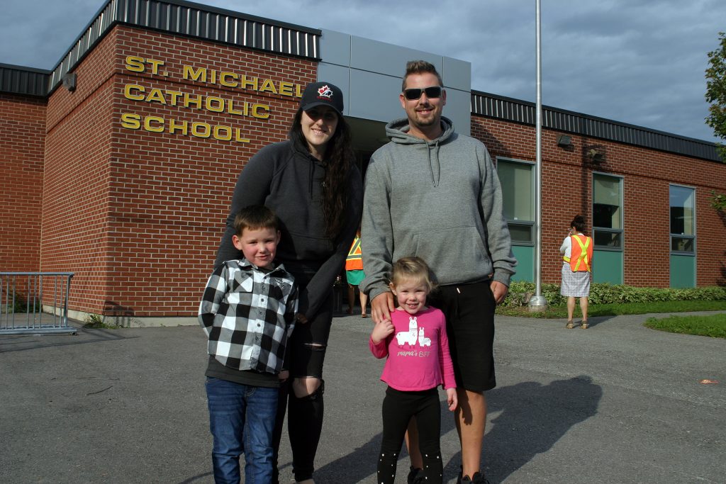 The Daze family poses for a photo in front of St. Michael's Catholic School.