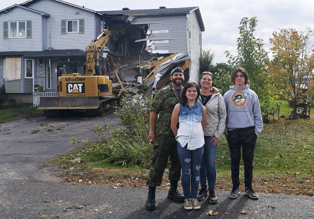 The Campbell family pose in front of their home.