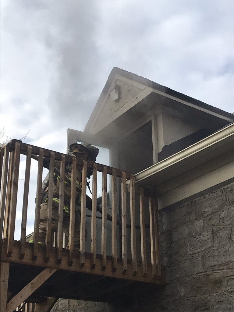 Firefighters attack the fire from an outdoor staircase.