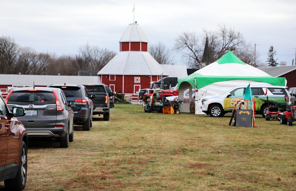 A line up of cars proceeds through Dave Creighton's drive-through wake Saturday.