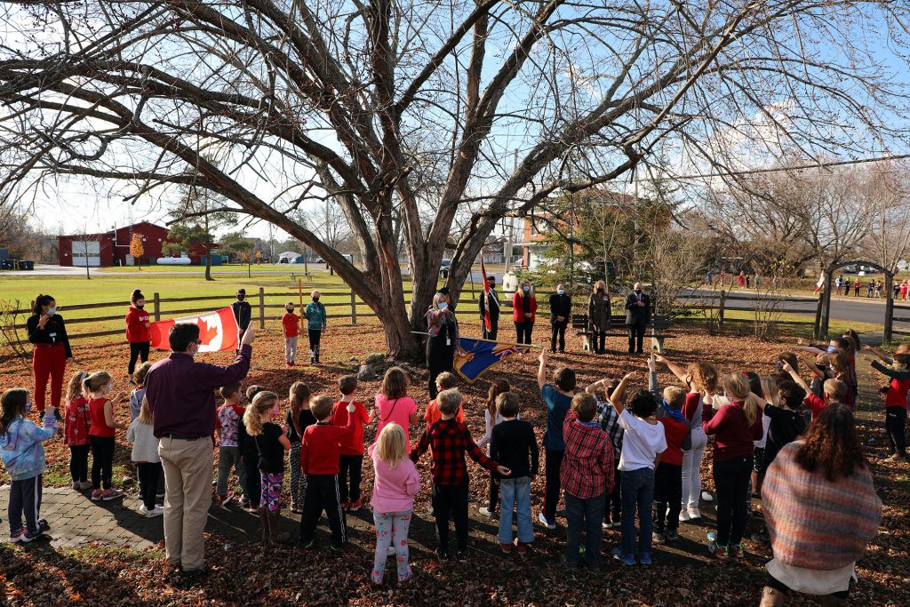 Students, staff and dignitaries sing O Canada.