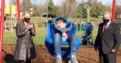 Liam goes for a swing with MP Karen McCrimmon and Coun. Eli El-Chantiry.