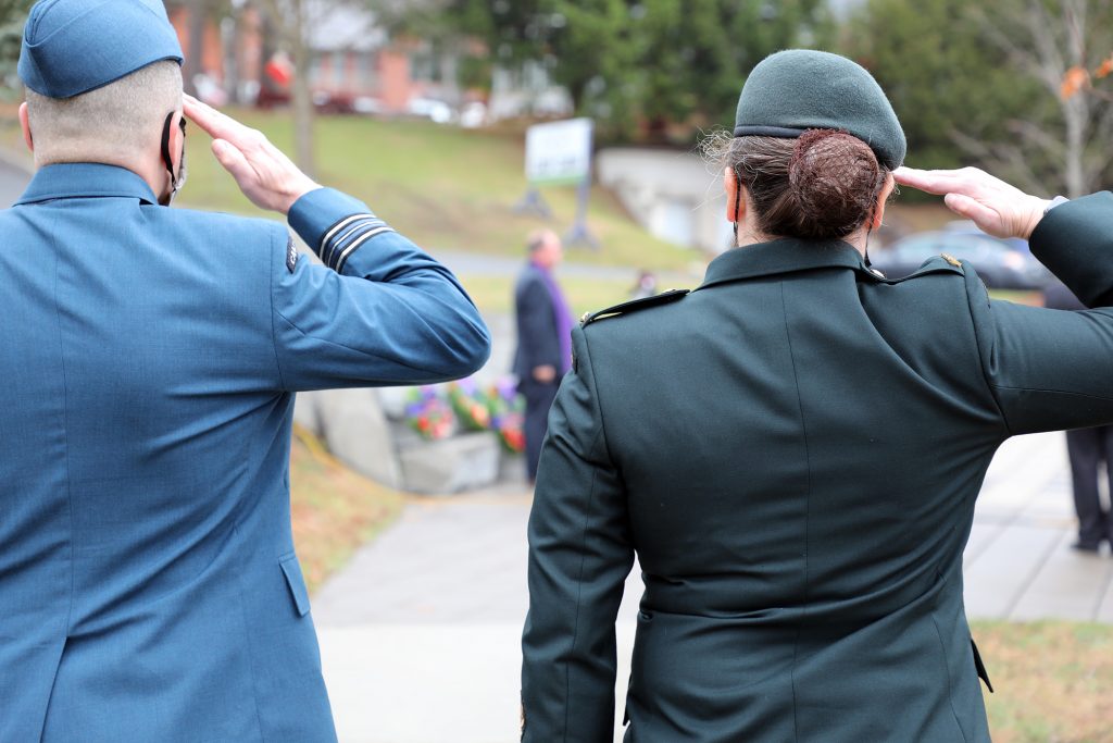 Two members of the military salute during the singing of the national anthem.