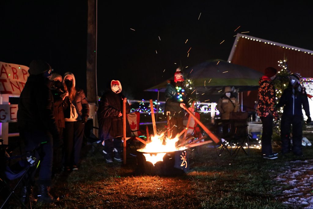 The 9th Carp Pathfinder Rangers keep warm by the fire during a parade that saw nearly 1,000 cars.