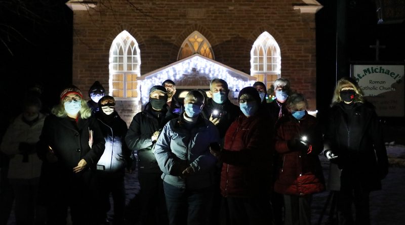 A group of carolers poses in front of St. Michael's Church last Saturday.